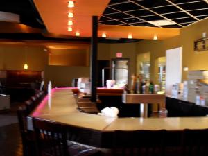 a bar in a restaurant with a counter and chairs at Travelodge by Wyndham Regina in Regina