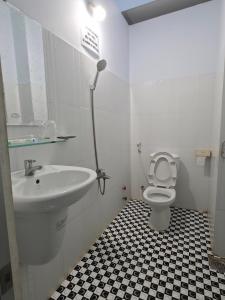 a white bathroom with a sink and a toilet at Khách sạn Thảo Minh in Lagi