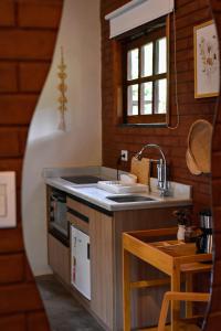 a kitchen with a sink and a counter top at Chalés Vila Do Vale in Vale do Capao