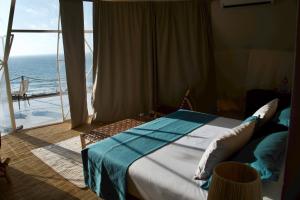 a bedroom with a bed with a view of the ocean at Ksar Massa in Rbat +44 photos