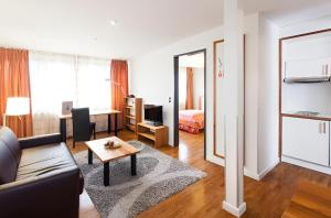 a living room with a couch and a bedroom at Juno Suites Bremen City in Bremen