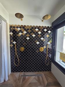 a bathroom with a black and white tiled wall at Villa Lumineuse in Nyons
