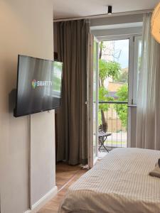 a flat screen tv on a wall in a bedroom at Boulevard Studios NewBorn in Prishtinë