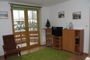 ein Wohnzimmer mit einem TV und einem Stuhl in der Unterkunft Apartament DOMINO in Karpacz
