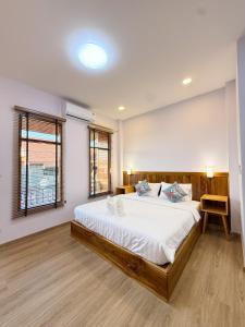 a bedroom with a large bed with white sheets at Wansuk Chiangkhan in Chiang Khan