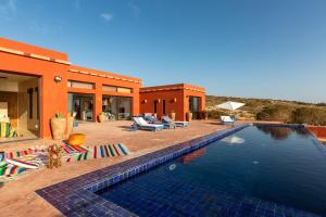 a swimming pool in front of a house at Ksar Massa in Rbat