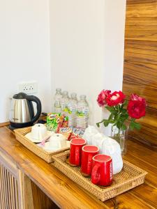 a counter with red cups and plates and water bottles at Wansuk Chiangkhan in Chiang Khan