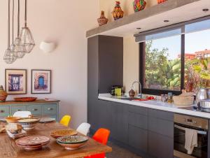 a kitchen with a wooden table with chairs and a counter at Ksar Massa in Rbat