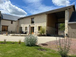 a large stone building with a courtyard in front of it at Gîte "Les Pièces du Moulin" in Angliers