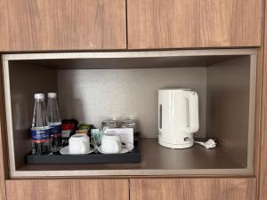 a shelf with a coffee maker and coffee cups at Sky villa on the beach in Cat Ba