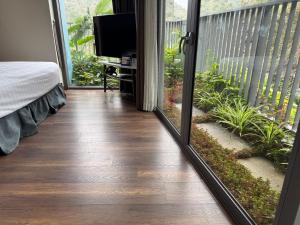 a room with a balcony with a bed and a television at Sky villa on the beach in Cat Ba