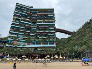 a tall building on the beach with people standing in front of it at Sky villa on the beach in Cat Ba +7 photos