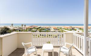 a balcony with chairs and a table and a view of the beach at Hotel Oceano in Marina di Pietrasanta