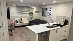 a kitchen and a living room with a couch at Comfy-home in YYC