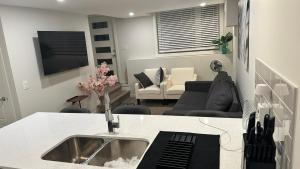 a kitchen with a sink and a living room at Comfy-home in YYC