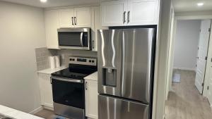 a kitchen with a stainless steel refrigerator and microwave at Comfy-home in YYC