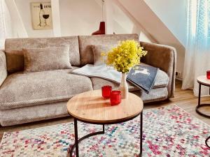 a living room with a couch and a table with flowers at Thüringer Wald-Zauber in Zella-Mehlis