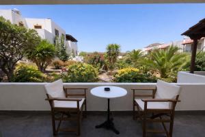 a table and chairs on a balcony with plants at Medina in Skala