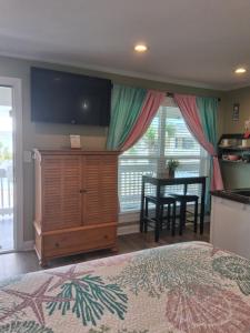a bedroom with a bed and a desk and a television at Carolina Blue in North Myrtle Beach