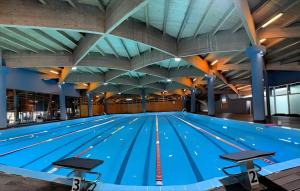 a large swimming pool with blue water at Big Center Beachfront Apartment in Durrës