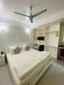 a bedroom with a large white bed with a ceiling fan at ZAN Lodge in Male City +14 photos