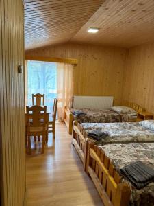 a room with four beds and a table and a dining room at Cube in Kvasy