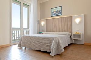 a bedroom with a bed and a large window at Hotel Oceano in Marina di Pietrasanta