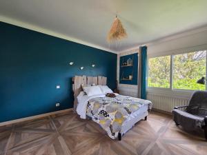 a bedroom with a bed and a blue wall at Villa Lumineuse in Nyons