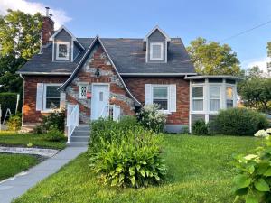 a brick house with a white door at Au coq du bonheur in Magog-Orford