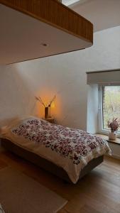 a large bed in a bedroom with a window at Chez Firmin in Manhay