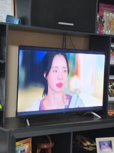 a television with a woman on the screen on a shelf at Juaky market y alojamiento in Garupá