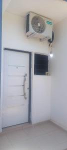 a white garage with a door and a fan at Juaky market y alojamiento in Garupá