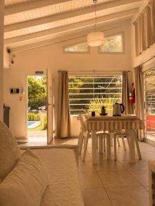 a dining room with a table and a window at Cabañas Aires del Sur, con gran parque y pileta in Chascomús