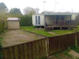 a mobile home in a yard with a fence at Camping les sumacs in Combles