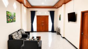 a living room with two chairs and a tv at Griya Mentari Homestay in Yogyakarta