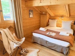 a bedroom with a bed in a log cabin at La Framboiseille - Chalet de Luxe avec Piscine Intérieure et Sauna - Vue Montagne in Manigod