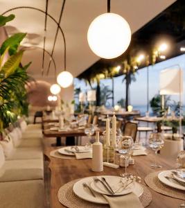 a dining room with tables and chairs and lights at Big Center Beachfront Apartment in Durrës