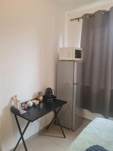 a table with a microwave on top of a refrigerator at Comfortable Secure Business Stay in Johannesburg