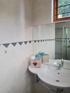 a white bathroom with a sink and a mirror at Comfortable Secure Business Stay in Johannesburg +6 photos