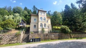 a house on a stone wall next to a street at Waldvilla in Bad Schandau