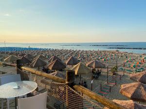 a beach with many umbrellas and chairs and the ocean at La casa di John in Guglionesi