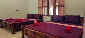 a bedroom with two beds with red pillows at MSM Surf Camp in Arugam Bay