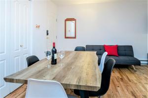 a dining room with a wooden table and wine glasses at Charming Condo - Perfect for Visiting Quebec City in Quebec City