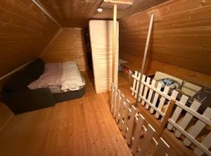 a small room with a bed in a wooden cabin at Hytta Kilpisjärvi in Kilpisjärvi