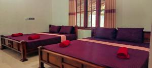 a bedroom with two beds with red pillows at MSM Surf Camp in Arugam Bay