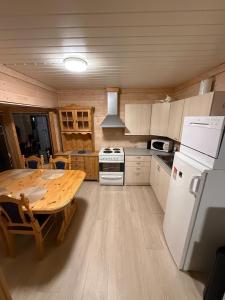 a kitchen with a wooden table and a white refrigerator at Hytta Kilpisjärvi in Kilpisjärvi