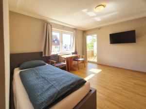 a bedroom with a bed and a dining room with a table at Weinhof Hornstein - Appartements in Nonnenhorn