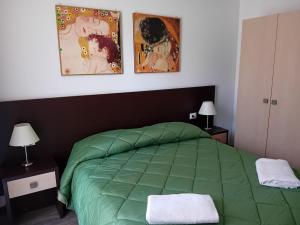 ein Schlafzimmer mit einem grünen Bett und zwei Nachttischen in der Unterkunft Room 119 in Tortoreto Lido