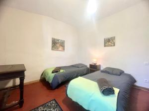 two beds in a room with a piano and a table at Le Moun Mazet gîte rural 3 étoiles, CLIM, Nature, 6 personnes in Miramas