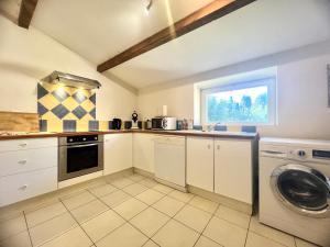 a kitchen with white cabinets and a washer and dryer at Le Moun Mazet gîte rural 3 étoiles, CLIM, Nature, 6 personnes in Miramas